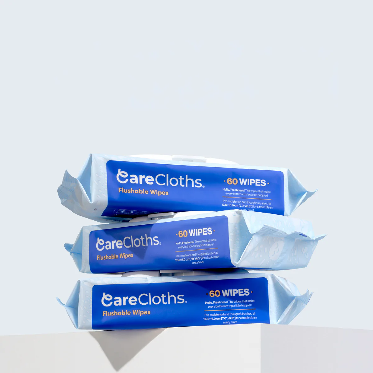 Three packs of CareCloths Flushable Wipes, 60 wipes each, stacked on a pedestal
